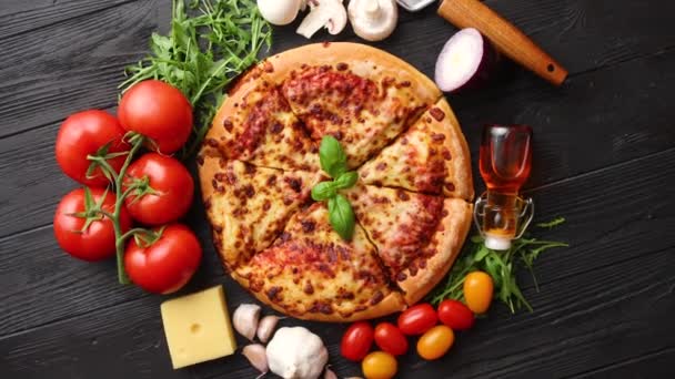 Deliciosa pizza italiana servida sobre mesa de madera negra — Vídeos de Stock