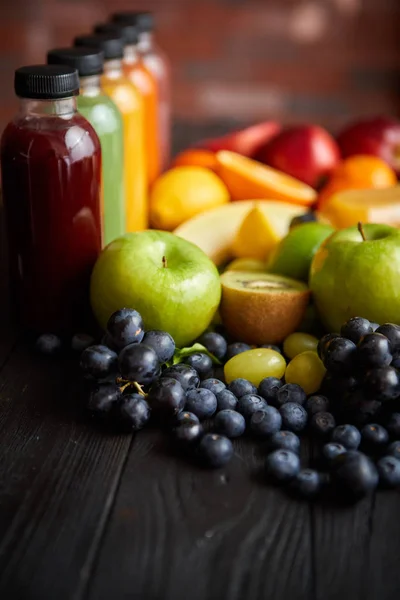 Bouteilles colorées remplies de jus de fruits et légumes frais ou smoothie — Photo