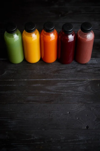 Красочные бутылки со свежими фруктами и овощным соком или смузи — стоковое фото