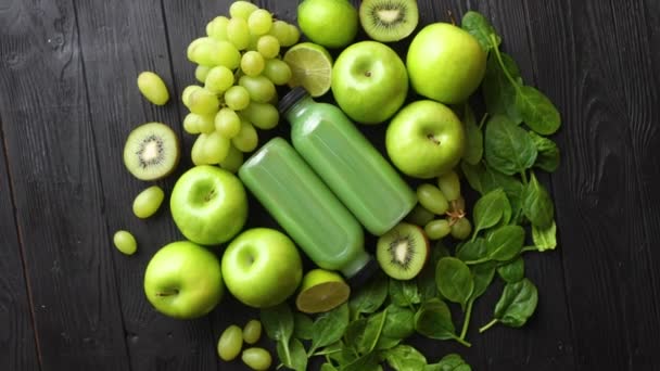 Gemengde groene groenten en fruit geplaatst op zwarte houten tafel — Stockvideo