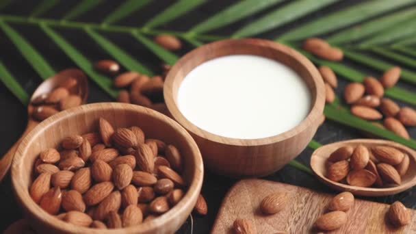 Primer plano de Almendras en tazón de madera y leche de almendras — Vídeos de Stock