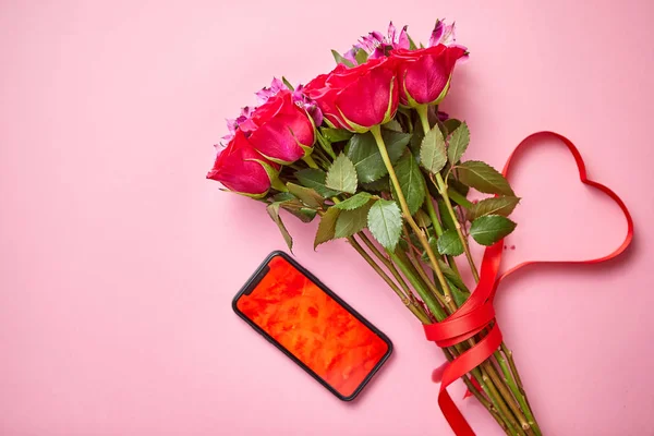 粉红玫瑰花束与哈特形弓和手机与复制空间屏幕 — 图库照片