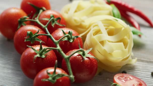 Manojos de pasta sin cocer con tomates — Vídeo de stock