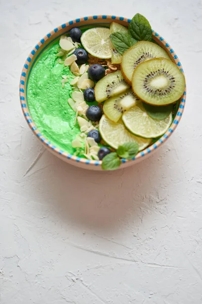 Grüner Smoothie oder Joghurtschale vorhanden. Mit frischen Kiwi, Blaubeeren, Limetten und Mandelflocken — Stockfoto