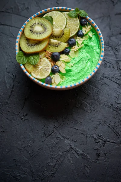 Grüner Smoothie oder Joghurtschale vorhanden. Mit frischen Kiwi, Blaubeeren, Limetten und Mandelflocken — Stockfoto