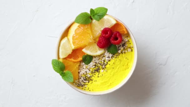 Tasty orange fresh smoothie or yogurt served in bowl. With raspberries, orange slices, chia seeds — Stock Video