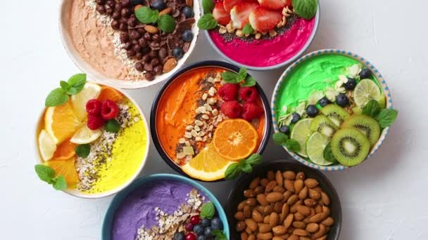 Diverse gezonde verse smoothies of yoghurt in kommen. met aardbeien, kiwi 's, chia' s, bramen — Stockvideo