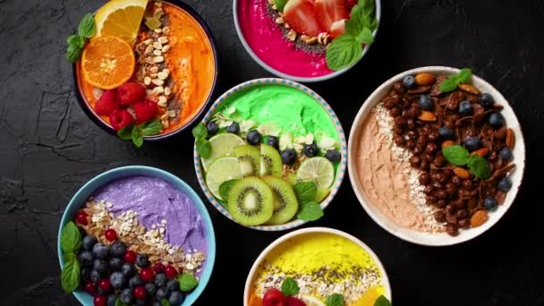 Vários smoothies frescos saudáveis ou iogurtes em tigelas. Com morangos, kiwi, chia, amoras — Vídeo de Stock