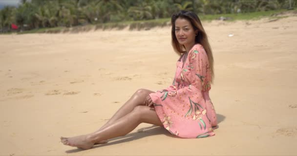 Mezítlábas etnikai nő ül a strandon — Stock videók