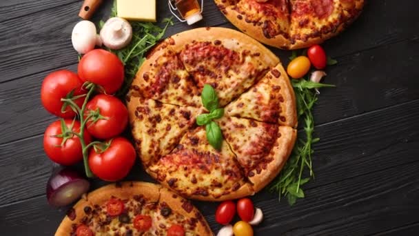 Frescamente servido, três várias pizzas colocadas entre ingredientes saborosos. Vista superior — Vídeo de Stock