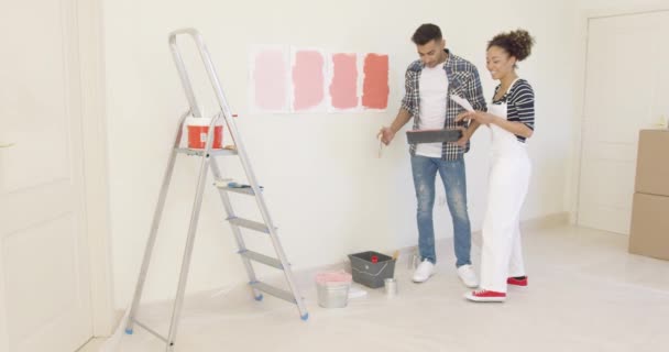 Pareja joven discutiendo tonos de color de la pintura — Vídeo de stock