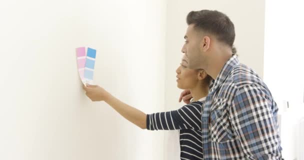 Молодая пара пытается выбрать цвет краски — стоковое видео