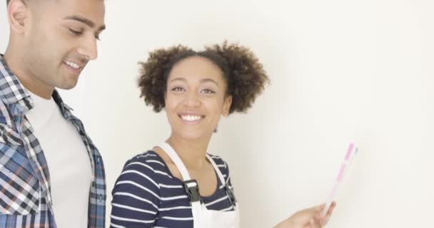 Pareja joven eligiendo un color de pintura — Vídeo de stock