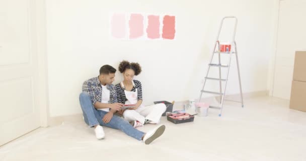 对年轻的夫妇用平板电脑来讨论颜色 — 图库视频影像