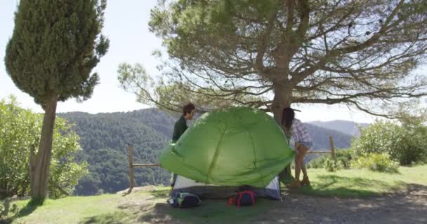 Two travellers putting up tent — Stock Video