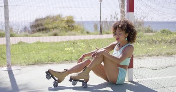 Junge, fitte Frau posiert auf Rollschuhen — Stockvideo