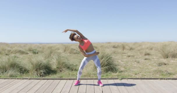 Sportieve vrouw die zich uitstrekt op de stoep — Stockvideo