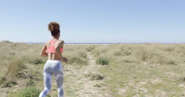 Жінка біжить на пляжі — стокове відео