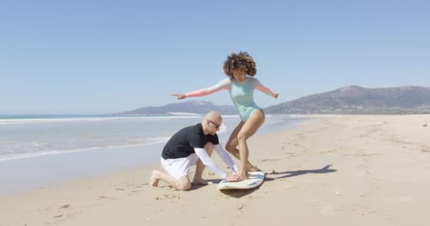 Uomo insegnamento donna in piedi sul surf — Video Stock