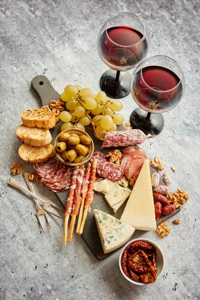 Tavola degli snack freddi con salumi, uva, vino, vari tipi di formaggio — Foto Stock