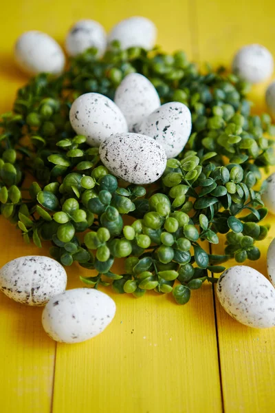 Gröna dekorativa påsk vaktel ägg krans på gula träbord — Stockfoto