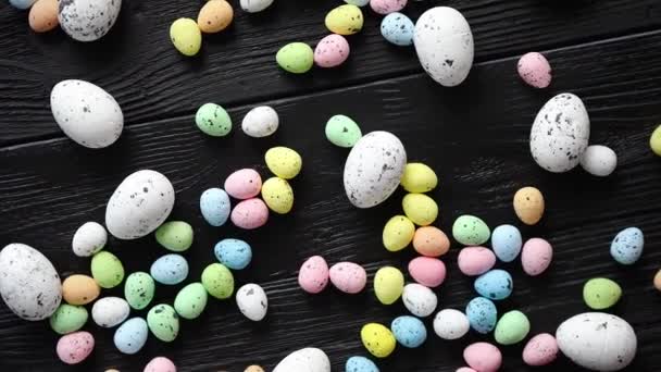 Easter holidays concept. Colorful different kinds of eggs placed on black wood — Stock Video