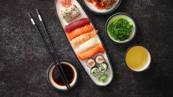 Asiatiskt matsortiment. Olika sushirullar som placeras på keramiska plattor — Stockvideo