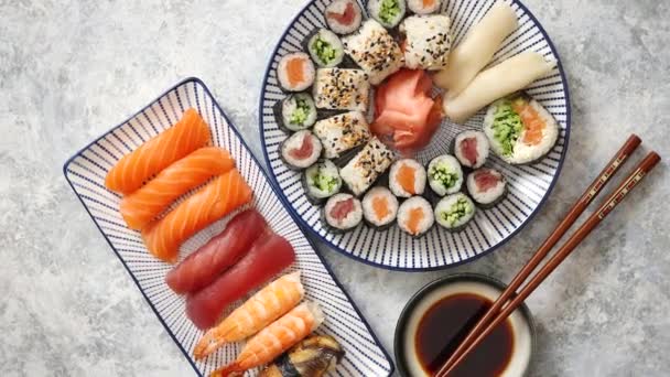 Assortiment alimentaire asiatique. Divers rouleaux de sushi placés sur des plaques en céramique — Video