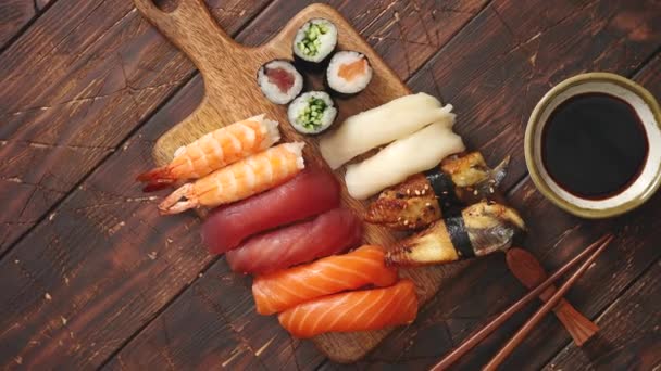 Sushi-setet. Olika sorters sushirullar på serveringsbord av trä — Stockvideo