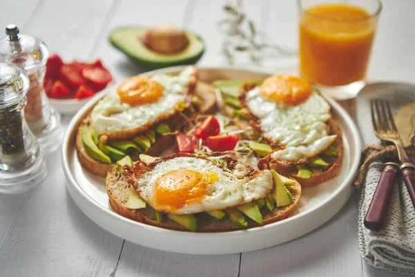 Delicioso desayuno saludable con sándwiches de aguacate en rodajas con huevo frito — Foto de Stock