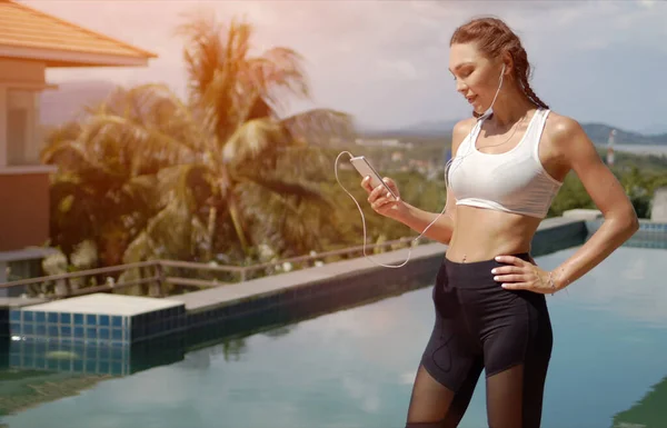 Atlet yang percaya diri menggunakan smartphone di tepi kolam renang — Stok Foto