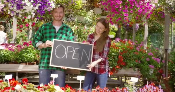 Két virágárus nyitott táblával a boltjában. — Stock videók