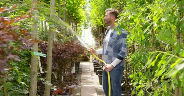 El hombre regando las plantas en el jardín — Vídeos de Stock