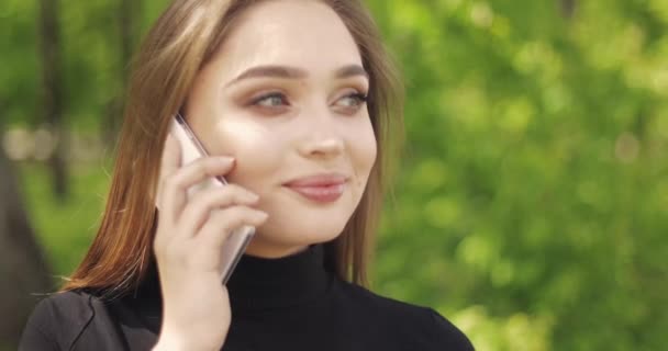 Retrato de hermosa mujer hablando teléfono y riendo mientras mira hacia otro lado — Vídeo de stock