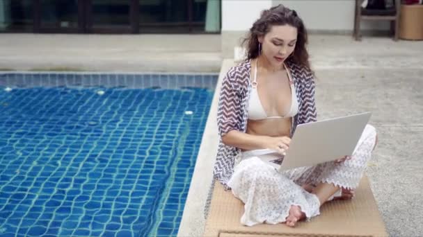 Жінка-туристка використовує ноутбук на шезлонгу — стокове відео