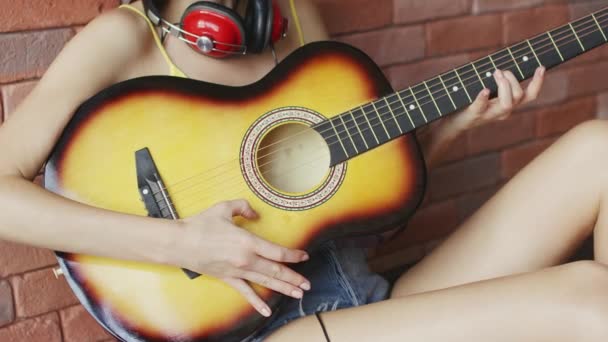 Manos de mujer anónima recogiendo cuerdas mientras toca en la guitarra acústica — Vídeo de stock