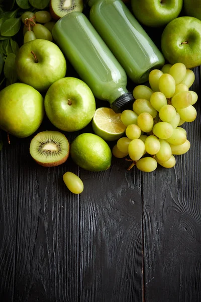 Fruits et légumes verts mélangés placés sur une table en bois noir — Photo