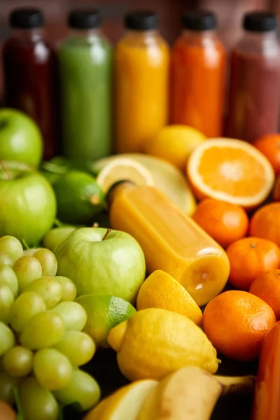 Coloridas botellas llenas de zumo o batido de frutas y verduras frescas —  Fotos de Stock