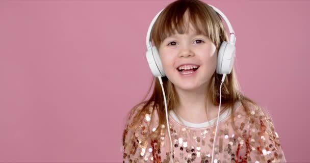 漂亮的6或7岁小女孩用耳机唱歌跳舞 — 图库视频影像
