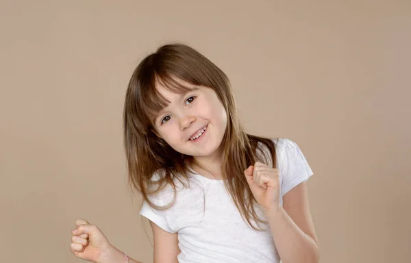 Menina bonito em branco tshirt dançando, sorrindo e se divertindo na sessão de estúdio — Fotografia de Stock