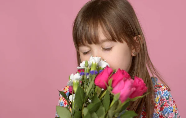 Bonito jovem adorável menina segurando e cheiro buquê de flores frescas — Fotografia de Stock