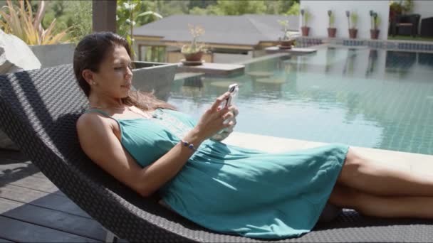 Жінка використовує смартфон біля басейну — стокове відео