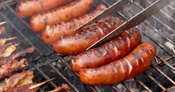 Hot tasty grilled sausages frying on smoking barbecue. Slow motion video — Stock Video