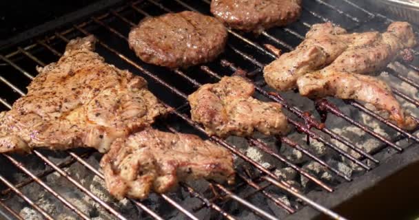 Gustosi hamburger di carne e carne di maiale grigliate sul barbecue fumante caldo. Video al rallentatore — Video Stock