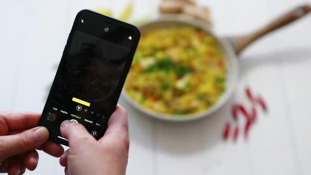 Nő fényképezés mobiltelefon finom sült rizs csirke tálalva serpenyőben — Stock videók