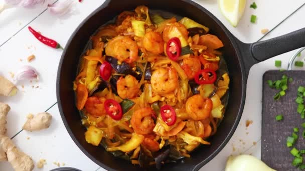 Fresh fried noodles with vegetables with shrimps served in black iron pan. With various ingredients — Stock Video