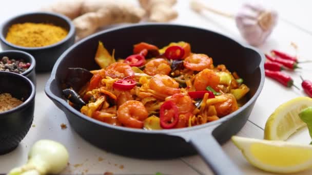 Falling chive on Fresh fried noodles with vegetables with shrimps served in black iron pan — Stock Video