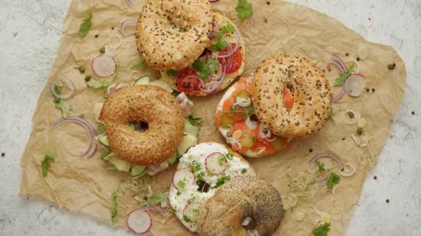 Körkörös kenyér bagel szendvics feltéttel tálalva. Samlon, sonka és sajt, kunyhó, humusz — Stock videók
