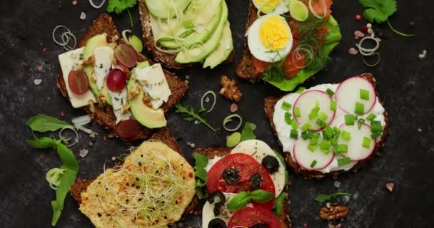 Surtido de sándwiches caseros con diversos ingredientes. Con coloridas verduras frescas — Vídeos de Stock