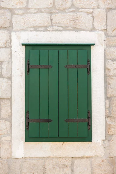 Closed green shuttered weathered wooden window Stock Photo